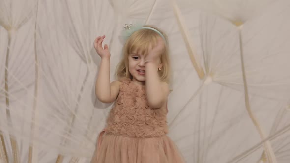 Happy Three Years Old Girl Make Faces and Dancing. Cute Blonde Child