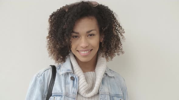 Afro American Girl in Casual Clothes Is Looking at Camera and Smiling