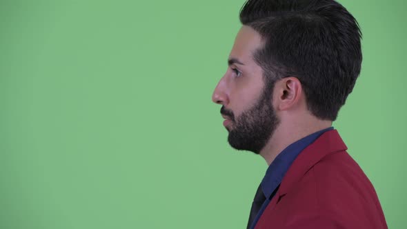 Closeup Profile View of Happy Young Bearded Persian Businessman in Suit Talking