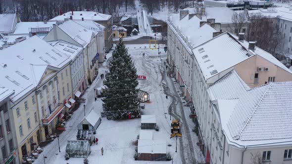 drone shot of Christmas tree in Tartus down square, tractor pushes the snow