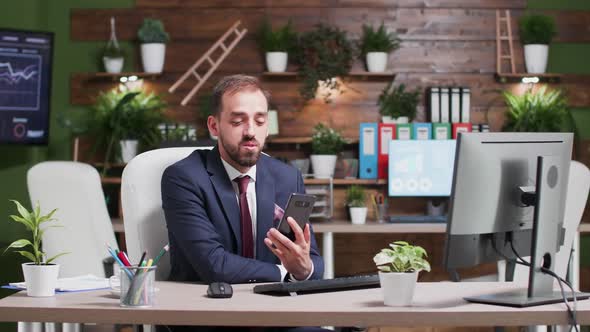 Large Shot of Businessman in Formal Suit Having a Video Conversation Using His Phone