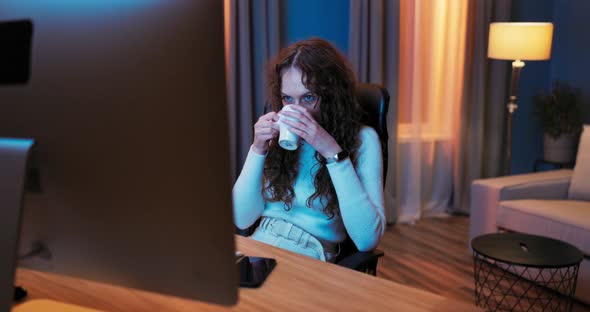 Tired After Work Young Girl Rests in the Evening Sitting in Front of the Computer alt