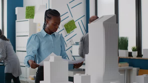 Portrait of Woman Architect Looking at Blueprints Plan to Find Inspiration for Construction Layout