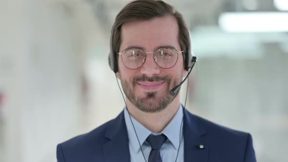 Young Businessman with Headset Smiling at the Camera