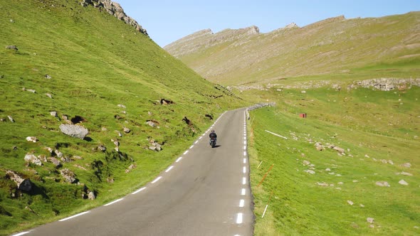 A Motorbike Passes on a Straight Road in Faroe Islands