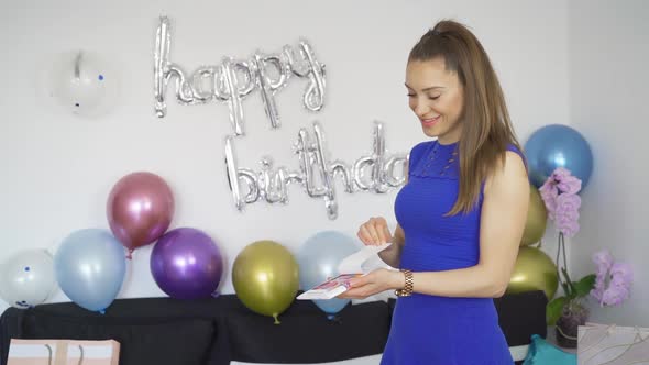 Surprised Woman Screaming After Opening Envelope with Surprise Confetti Box Inside