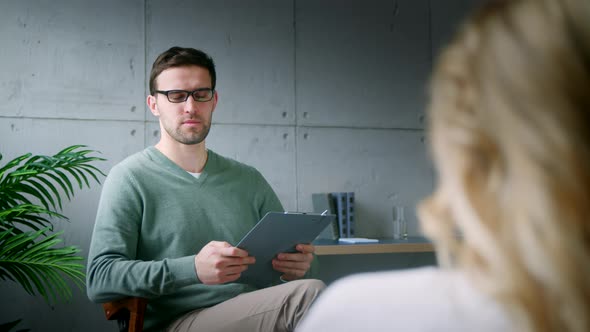 Young psychotherapist talking to a patient on a couch