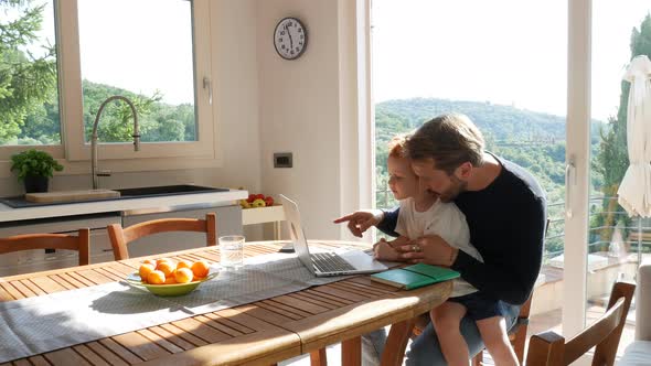 Father and son using laptop at home