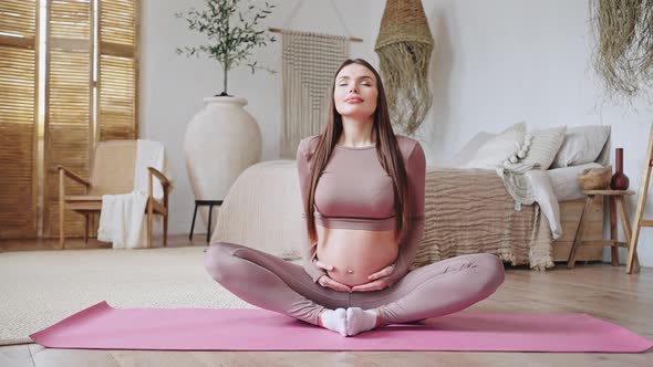 Pregnant Woman Enjoys Yoga in Lotus Pose Breathing Deep