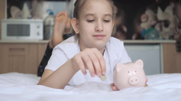 Girl Putting Coin in Piggy Bank Saving Money Concept