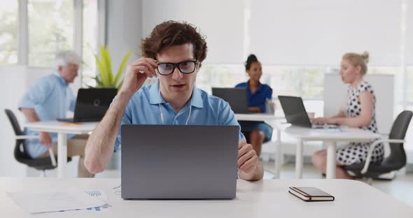 Successful Businessman in Earphones Making Video Call on Laptop