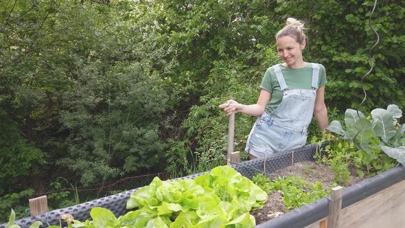 Slow motion shot of smiling gardener at raised bed