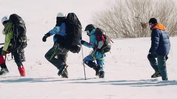 A Group of Professional Welltrained Hikers in Climbing Gear Moving Onwards Through the Snow