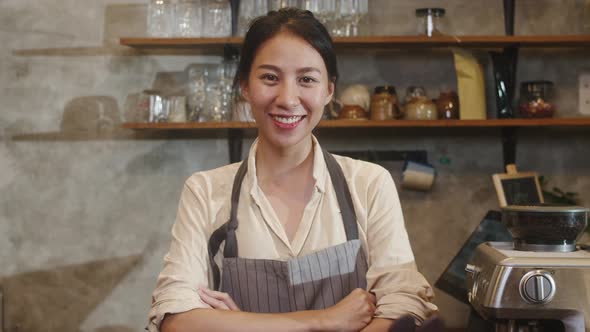 Asian woman barista feeling happy smiling at urban cafe.