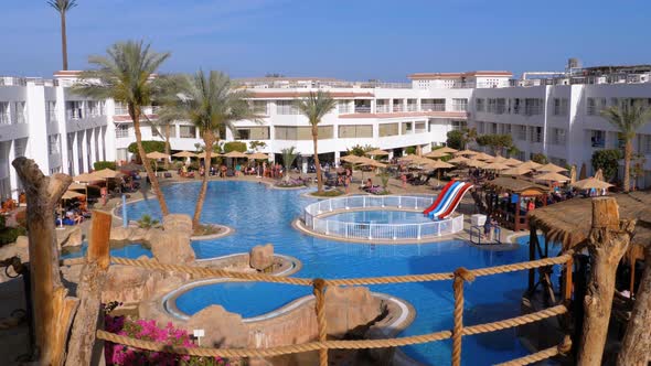 Sunny Hotel Resort with Luxury Blue Swimming Pool, Beach Umbrellas and Sunbeds in Egypt