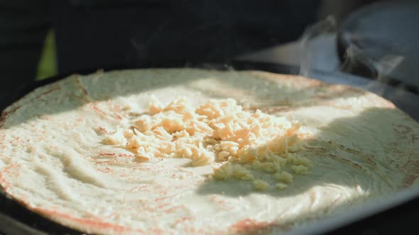 Side View of Cooking a Russian Pancake in a Professional Frying Pan