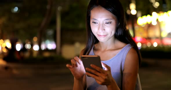 Young Woman Working on Cellphone at Night 