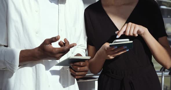 Close Up of Human Hands Holding Tickets, Male Fingers Point To Screen of Mobile Phone. Couple of