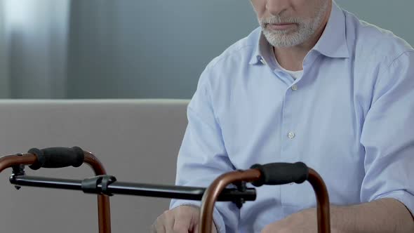 Old Man Sitting and Looking at Walking Frame, Spine Trauma, Indecisiveness