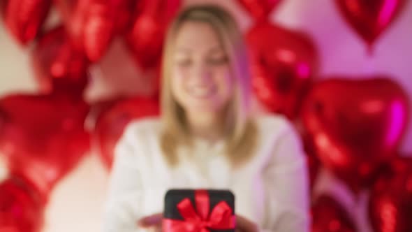 Joyful Surprised Smiling Blonde Woman Showing Elegant Prestige Black Gift Box