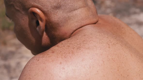 Tanned Shoulders Back of a Bald Male Resting on Nature