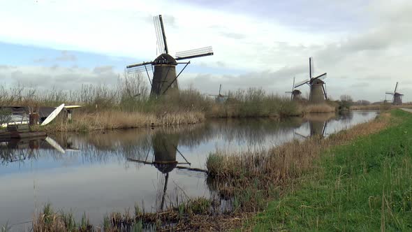 Dutch windmills in Kinderdijk reflect in the water.