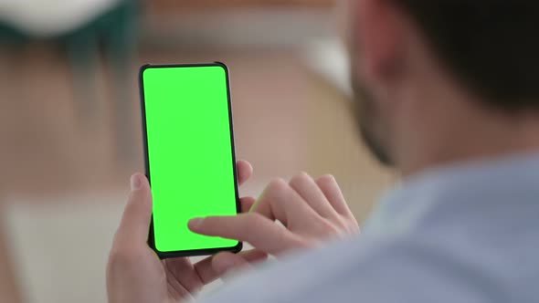 Young Man Using Smartphone with Green Chroma Screen