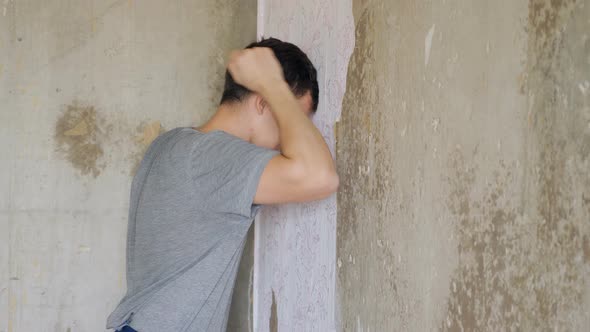 Depressed Man Standing and Beats Wall