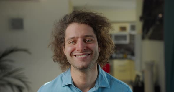 Closeup Portrait of an Attractively Curlyhaired Laughing Happy Young Man