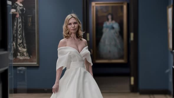 A Woman with Styled Hair Wearing Wedding Dress Posing in the Museum