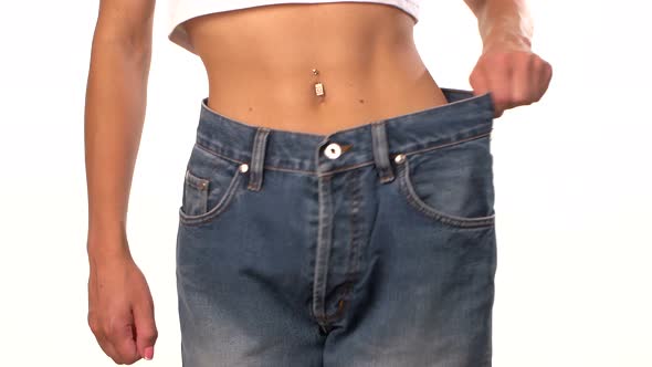 Slim Girl in Big Jeans, Showing Her Lose Weight, on White, Close Up