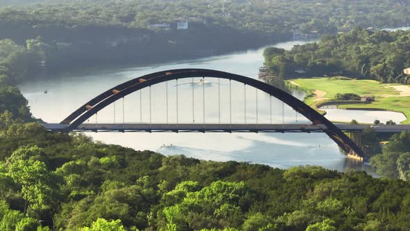 Rising up to reveal Pennybacker 360 bridge in Austin, Texas over Lake Austin during hazy summer morn