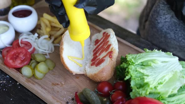 Making Hotdog  Woman Pouring Mustard Into Bun