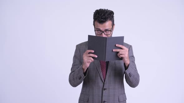 Shy Bearded Persian Businessman Covering Face with Book