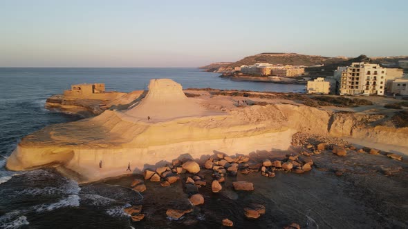 A cinematic view of the Xwejni salt pans towards the yellow Xwejni rock on the island of Gozo in Mal