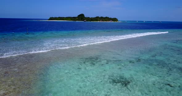 Tropical aerial travel shot of a white paradise beach and blue ocean background in vibrant