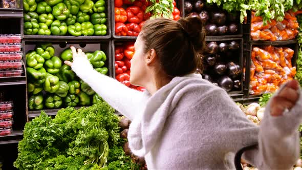 Woman buying capsicum in organic section