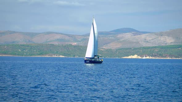 View Of Sailboat Cruising In The Adriatic Sea With Mountains In Background In Croatia, Europe.  - wi