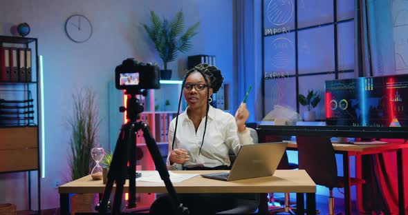 Businesswoman Holding Online Conference Using Camera in Evening Office and Explaining Results