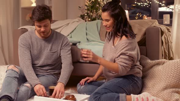 Happy Couple Drinking Coffee and Eating at Home