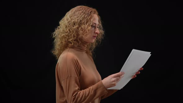 Side View of Focused Concentrated Woman Rehearsing Public Speech at Black Background