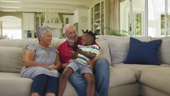 Grandparents and grandson using smartphone at home