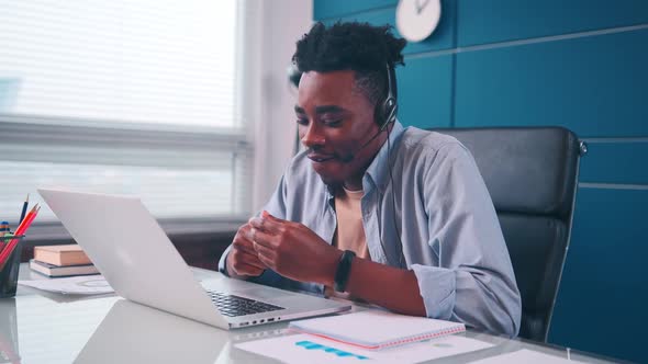 Confident African Businessman Wears Headset Makes Conference Call on Laptop
