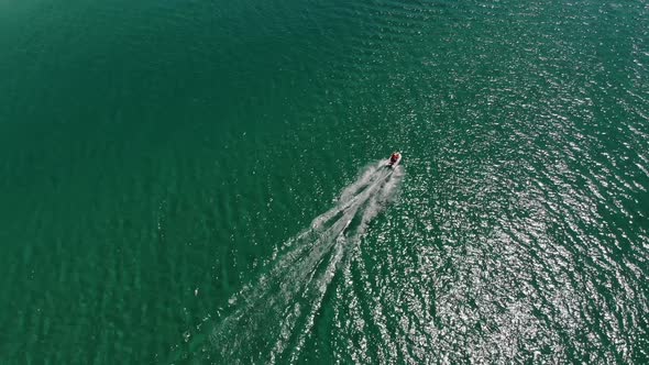 Aerial View of a Motor Boat Cruising Across the Clear Turquoise Sea on a Sunny Day