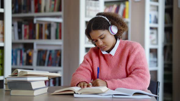 Female Student Doing Homework and Listening to Music