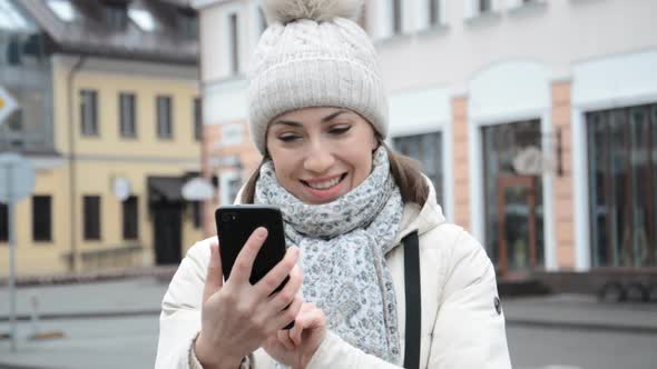 Front View of a Happy Caucasian Woman Using Smart Phone