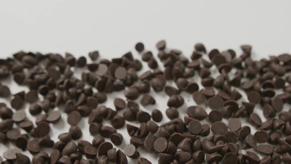 Video of close up of multiple chocolate chip with copy space over white background