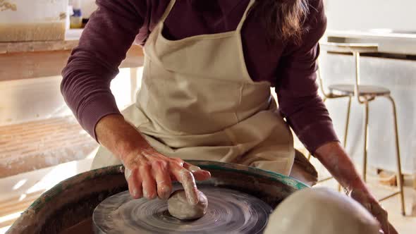Mid section of potter making pot