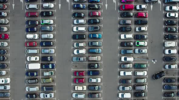 Time lapse aerial top view of a large parking lot near a shopping mall. alt
