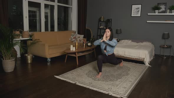 Yoga class at home. Young woman practices yoga at home. Flexible girl doing stretching